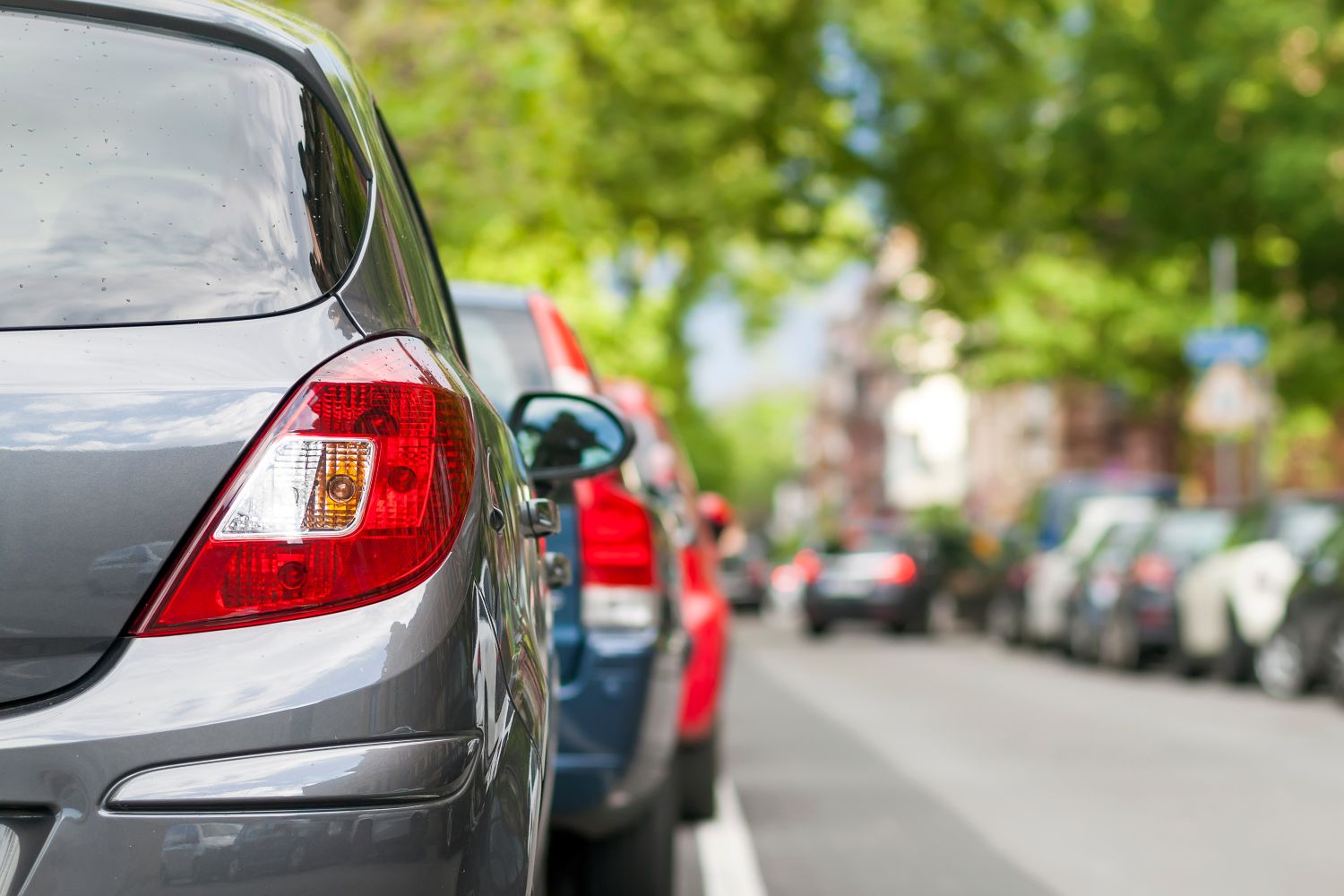 Rear view of multiple vehicles parked on a city street