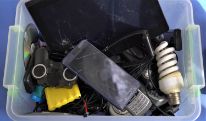 light bulbs, batteries, used cell phones in a bin