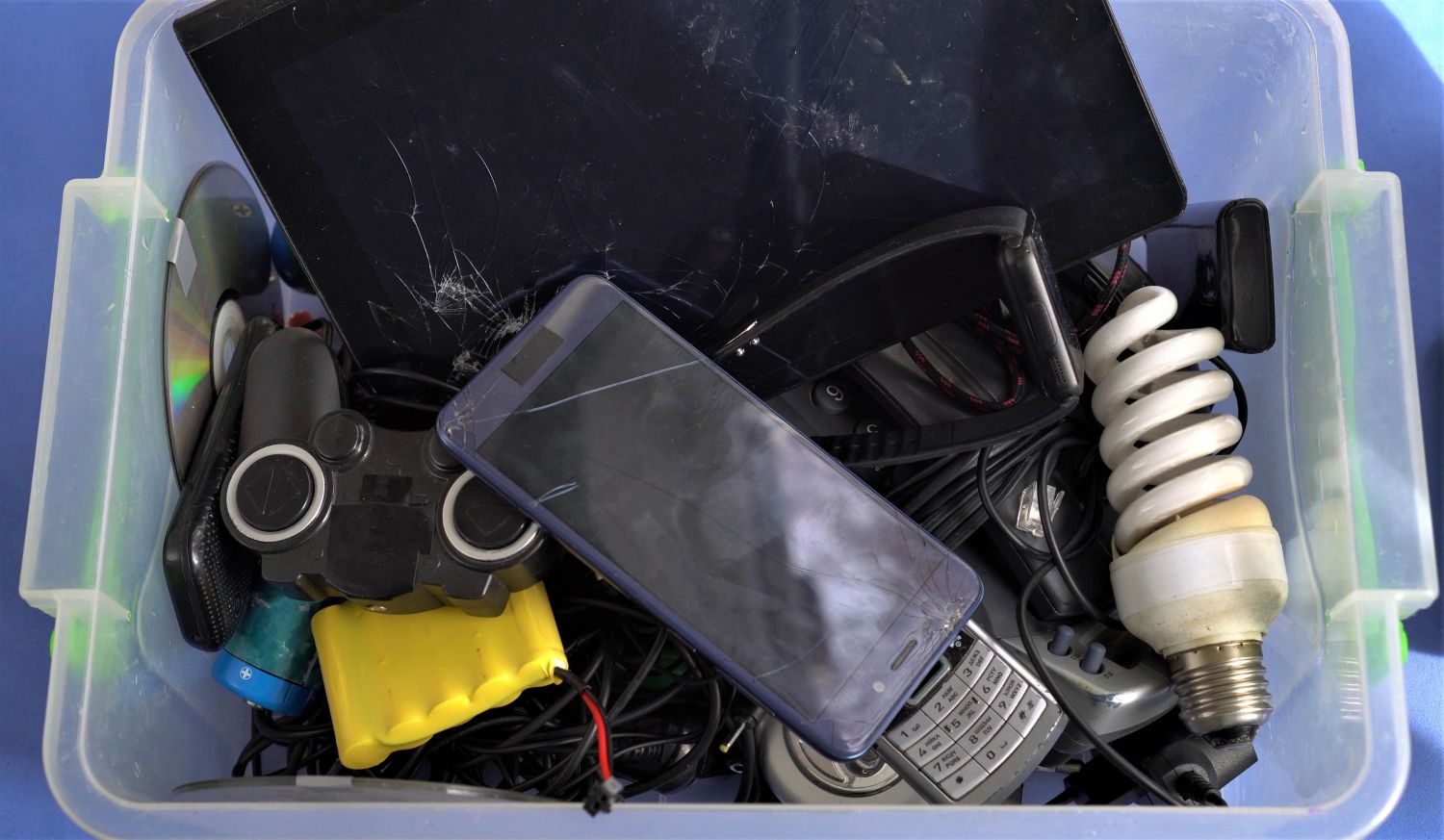 Hazardous waste in a plastic container including ewaste and light bulbs