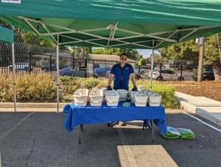 Booth at local community event with RSW staff and kitchen pails