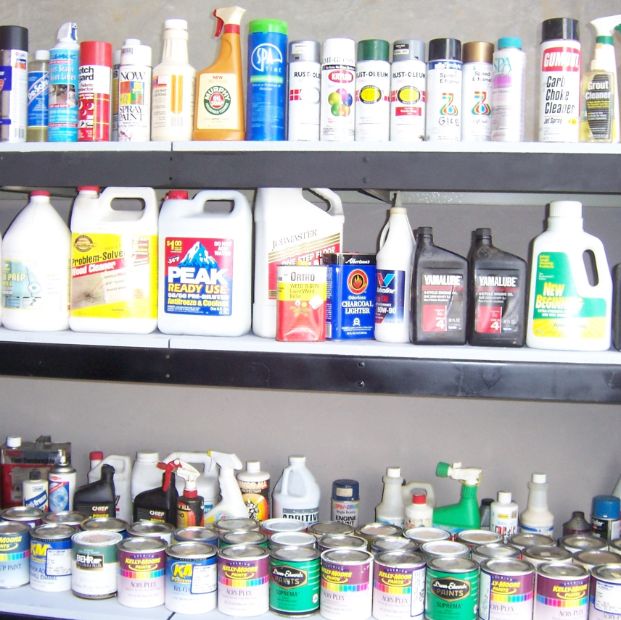 Shelves filled with hazardous waste products like paint and cleaners