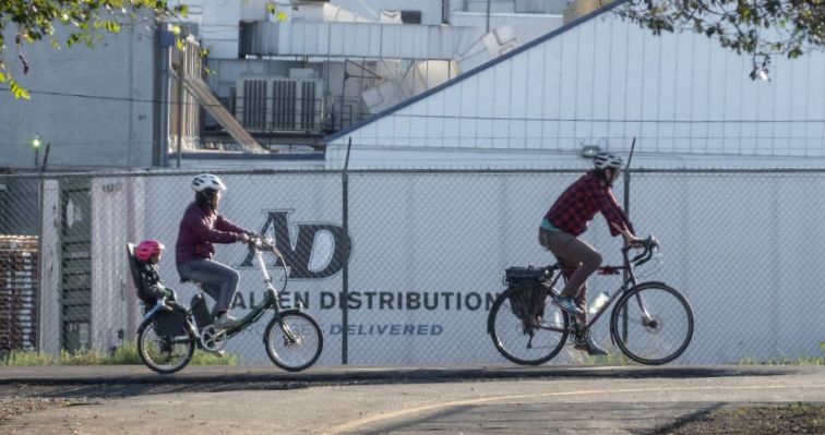 A photo of a path with people walking and biking