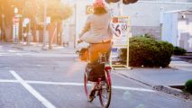 woman on a bike wearing a helmet riding down the street
