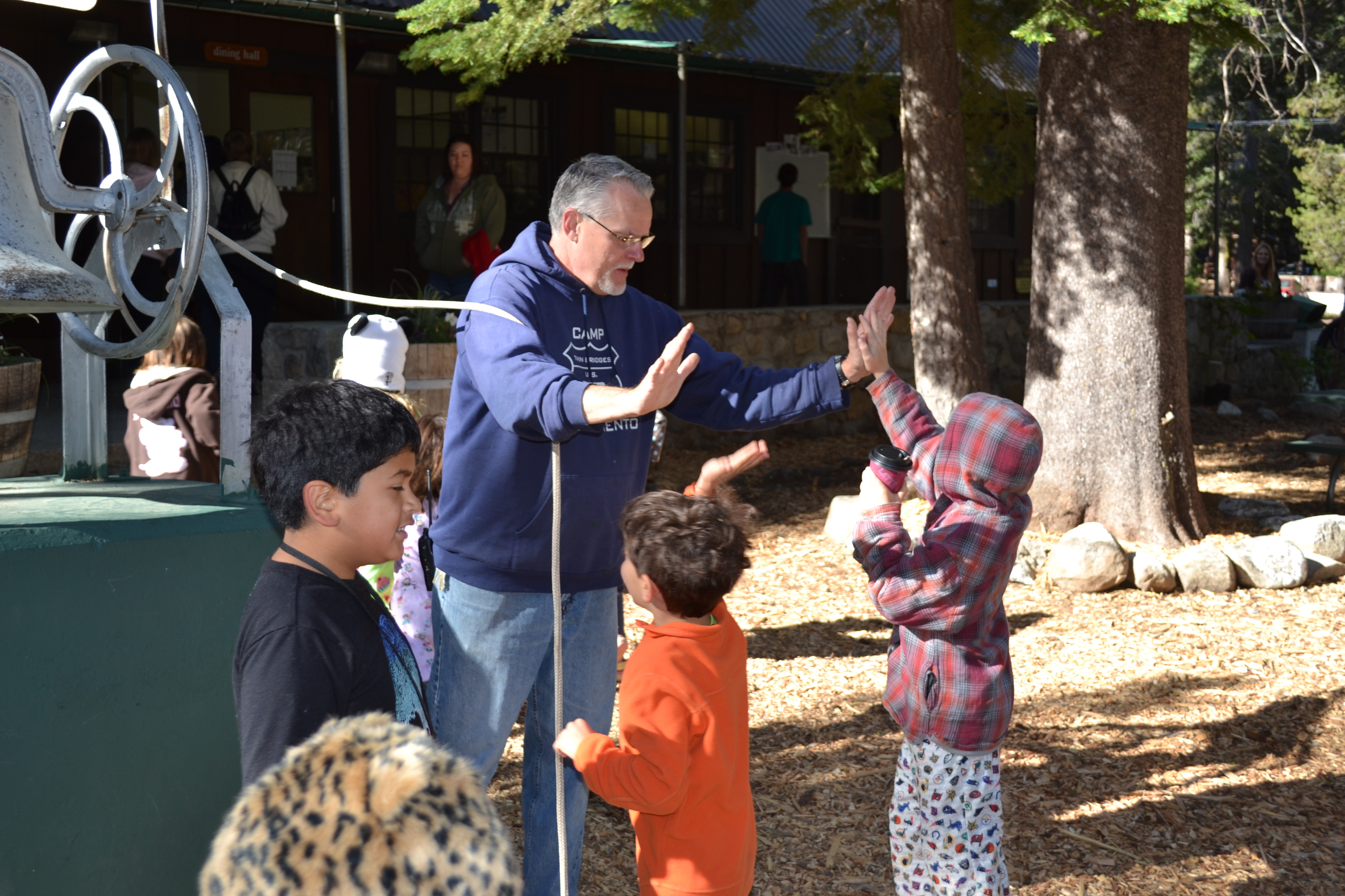 Image of a man high-fiving a kid by a bell