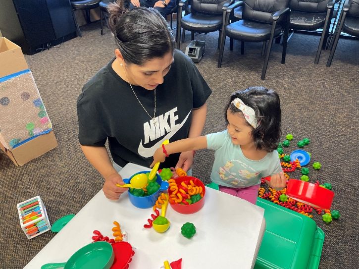 Adult and child co-playing with toys