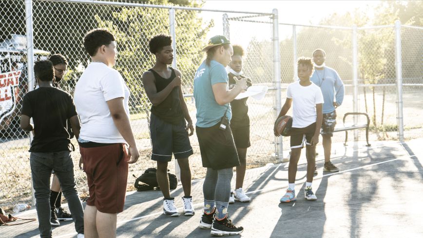 Teens playing basketball.